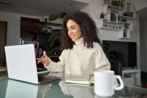 Happy latin woman hybrid working online at home having virtual meeting.